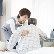 年配の方を介助する女性
